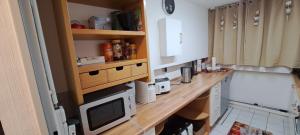 cocina con encimera de madera y microondas en Private 1-2,5 -Zimmer-Wohnung mit Terrasse, en Zülpich