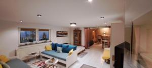 Una sala de estar con un sofá azul y un televisor en Private 1-2,5 -Zimmer-Wohnung mit Terrasse, en Zülpich