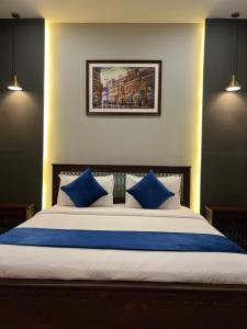 sypialnia z dużym łóżkiem i niebieskimi poduszkami w obiekcie Luxury 2-Bedroom Apartment with Balcony Skypark One Gulberg Greens Islamabad w mieście Islamabad +18 zdjęć