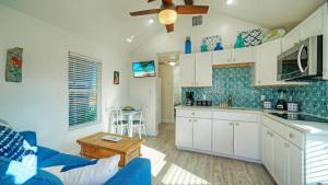 eine Küche mit weißen Schränken und einer blau gefliesten Wand in der Unterkunft Walk to Alister St Near Dining King Suite w Private Yard Fire Pit Casa Santori by AvantStay in Port Aransas