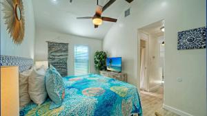 ein Schlafzimmer mit einem Bett und einem Deckenventilator in der Unterkunft Walk to Alister St Near Dining King Suite w Private Yard Fire Pit Casa Santori by AvantStay in Port Aransas
