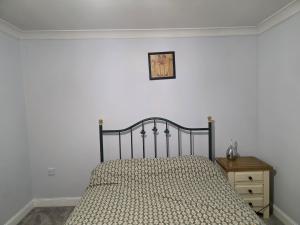 a bedroom with a bed and a clock on the wall at Stay Near Colchester twn centre2 in Hythe