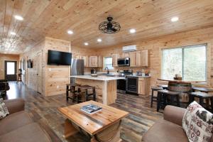 una cucina e un soggiorno in una baita di tronchi di Whiskey Duo 2 Cabins SidebySide HotTubs Firepit a Walnut Grove