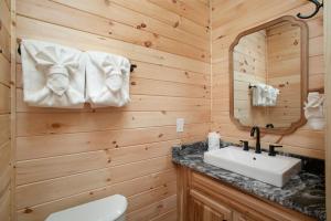 un bagno con lavandino e specchio di Whiskey Duo 2 Cabins SidebySide HotTubs Firepit a Walnut Grove Altre 68 foto