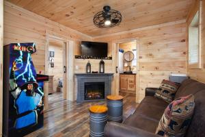 un soggiorno con divano e camino di Whiskey Duo 2 Cabins SidebySide HotTubs Firepit a Walnut Grove