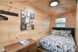 una camera da letto con un letto e una parete di legno di Whiskey Duo 2 Cabins SidebySide HotTubs Firepit a Walnut Grove