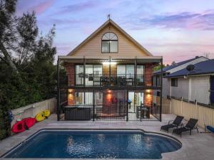a house with a swimming pool in front of a house at Dora Creek Escape with Pool and Spa in Dora Creek