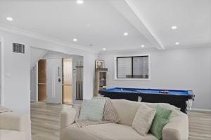 a living room with a couch and a pool table at Dora Creek Escape with Pool and Spa in Dora Creek