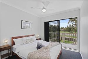 a bedroom with a bed and a large window at Dora Creek Escape with Pool and Spa in Dora Creek +20 photos