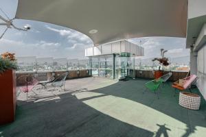 a balcony of a building with chairs and a shadow at The Urban Muse suite in Mexico City +5 photos