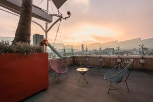 a patio with chairs and a table on a balcony at The Midnight Bloom Suite in Mexico City