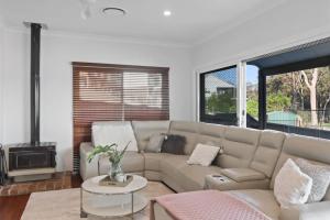 a living room with a couch and a table at Bayview Bliss Brightwaters in Morisset East