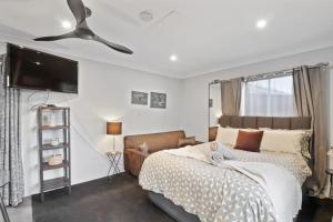 a bedroom with a bed and a ceiling fan at Bayview Bliss Brightwaters in Morisset East