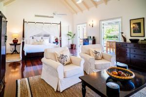 a living room with a bed and two chairs and a table at The Inn at English Harbour in English Harbour Town