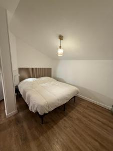 een slaapkamer met een bed in een witte kamer bij Face au chateau in Vizille