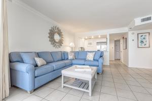Una sala de estar con un sofá azul y una mesa. en Beachside Two 4287, en Destin