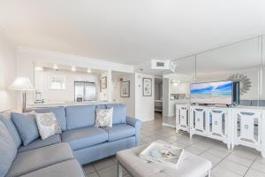 Una sala de estar con un sofá azul y un televisor en Beachside Two 4287, en Destin
