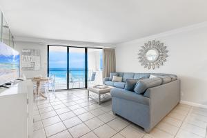 Una sala de estar con un sofá azul y una mesa. en Beachside Two 4287, en Destin