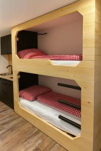 a bunk bed with red mattresses in a room at TinyAlps in Saalbach Hinterglemm