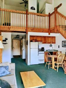 a living room with a staircase and a kitchen at Two Bedroom Loft Apartment Sleeps 8 with River Views near Loon Mountain in Lincoln