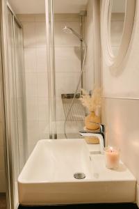 a bathroom with a sink with a shower and a candle at TinyAlps in Saalbach Hinterglemm +1 photo