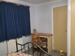 a room with a desk and a blue curtain at Home away from city noise Be in Hythe