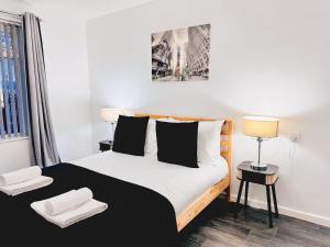 ブラッドフォードにあるCosy 1 bed flat, sleeps 4, free parkingのベッドとタオル2枚のある寝室