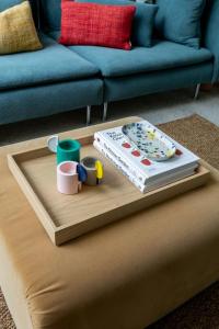 a coffee table with books and cups on top of a couch at Chic Seddon Retreat Near the CBD in Seddon