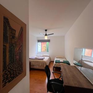 a room with two beds and a table in it at Casa Ibirapuera - Hospedagem in Sao Paulo