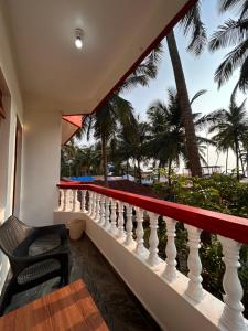 a balcony with a view of the beach and palm trees at Maria Paulo Guest House Bar and Restaurant in Agonda