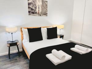 ブラッドフォードにあるCosy 1 bed flat, sleeps 4, free parkingのベッドルーム1室(白黒のベッド1台、ランプ2つ付)