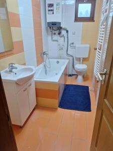 een badkamer met een bad, een wastafel en een toilet bij Kisház in Kisvárda +6 foto's