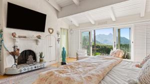 Schlafzimmer mit einem Bett, einem Kamin und einem TV in der Unterkunft Private Malibu Escape w Guest House Fire Pits Mountain Views The Malibu Retreat by AvantStay in Monte Nido
