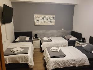 ザグレブにあるGuest House Lucijaのベッド3台、タオル付