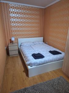 een slaapkamer met een bed met twee zwarte handdoeken erop bij Kisház in Kisvárda