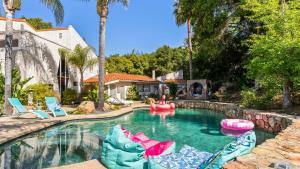 ein Schwimmbad mit aufblasbaren Gegenständen in einem Haus in der Unterkunft Private Malibu Escape w Guest House Fire Pits Mountain Views The Malibu Retreat by AvantStay in Monte Nido