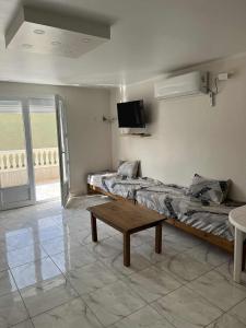 een kamer met twee bedden en een tafel erin bij Villa ziari in Skikda