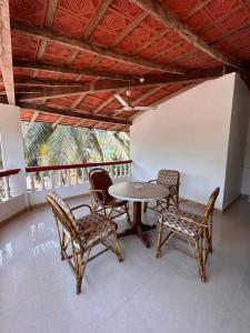 a patio with a table and chairs in a room at Maria Paulo Guest House Bar and Restaurant in Agonda