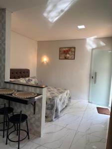 una habitación con una cama, una mesa y sillas en Chalé Roda Dágua C, en Caparaó Velho