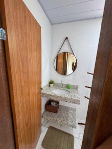 un baño con lavabo y espejo en Chalé Roda Dágua C, en Caparaó Velho
