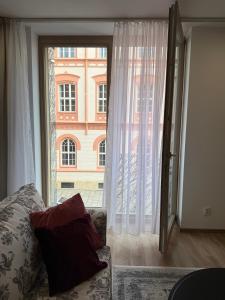 a living room with a couch and a large window at Veleslaveenka in Plzeň +10 photos