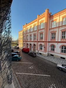 Un gran edificio con coches aparcados en un estacionamiento. en Veleslaveenka, en Plzeň 10 fotos más