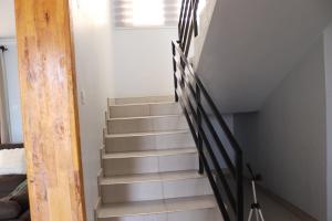 a staircase in a room with a stair railing at Tical Apartments in Lilongwe +5 photos
