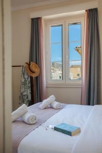 une chambre d'hôtel avec un lit, des serviettes et une fenêtre dans l'établissement The Lucky 12, à Corfu