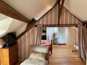 ein Dachzimmer mit einem Bett und einem Stuhl in der Unterkunft Family Cottage 4-6p with AC, Pool and Sauna in Pruniers + 28 Fotos