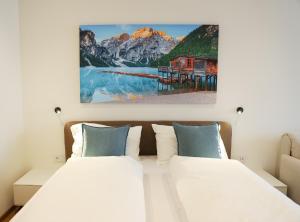 ブレッサノーネにあるecHo Apartments & SPAのベッドと壁に絵が飾られた寝室