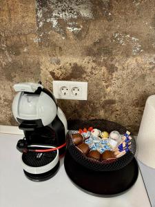Eine Kaffeemaschine steht neben einer Schachtel Pralinen. in der Unterkunft Apartament silver in Craiova