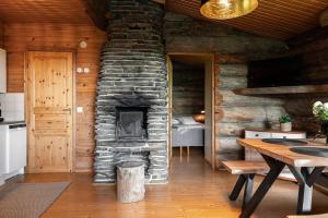 - une cuisine avec une cheminée en pierre dans une cabane en rondins dans l'établissement Charming Cottage on a Fell, à Pudasjärvi 14 autres photos