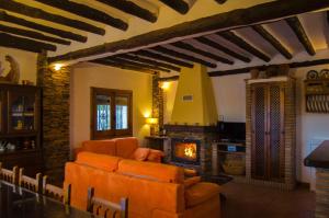 een woonkamer met een bank en een open haard bij Casa Nº9 in Válor +32 foto's