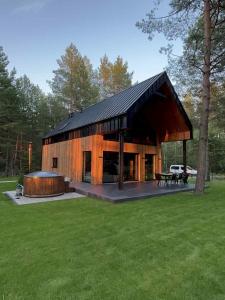 a large wooden house with a black roof at Chata w Puszczy Nowa Łuka in Łuka